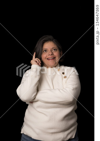 A woman is wearing a white sweater and is pointing her finger A woman is wearing a white sweater and is pointing her finger 134647869