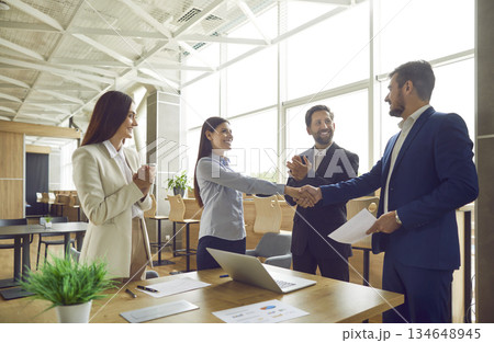 Business partners meet in the office, make successful deal and exchange handshakes Business partners meet in the office, make successful deal and exchange handshakes 134648945
