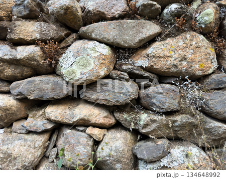 Old stone wall built of various sizes of rocks in a rural area 134648992
