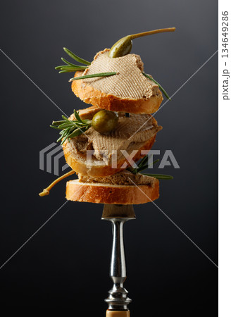 Sandwiches with liver pate garnished with rosemary and capers. 134649286