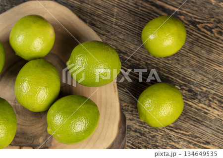 green ripe citrus limes scattered on a table in the kitchen, ripe and juicy lime fruits for cooking both sauces and drinks and other food 134649535