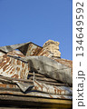 bent steel roof on a village house, details of a house in a rural area with a primitive roof that was badly damaged, an abandoned house 134649592