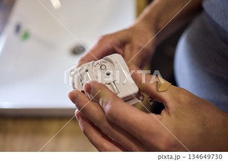 Disassembled Smart Device Displaying Its Circuit Board Alongside Various Components 134649730