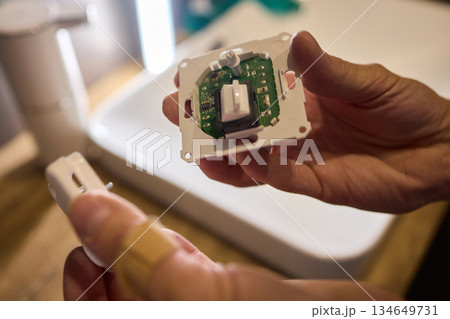 Disassembled Smart Device Displaying Its Circuit Board Alongside Various Components 134649731
