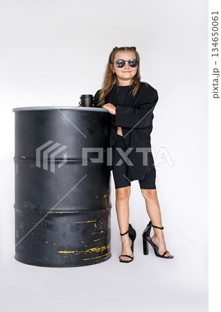 A stylish, fashionable girl in black sunglasses and her mother's high-heeled shoes A stylish, fashionable girl in black sunglasses and her mother's high-heeled shoes 134650061