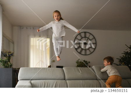 The children are jumping with joy on the sofa at Christmas 134650151