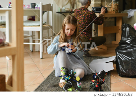 A girl unwraps the christmas presents A girl unwraps the christmas presents 134650168