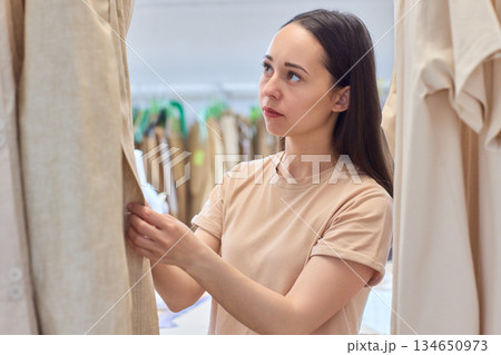 A Fashion Designer Carefully Organizing Beautiful and Elegant Dresses in Their Studio Workspace A Fashion Designer Carefully Organizing Beautiful and Elegant Dresses in Their Studio Workspace 134650973
