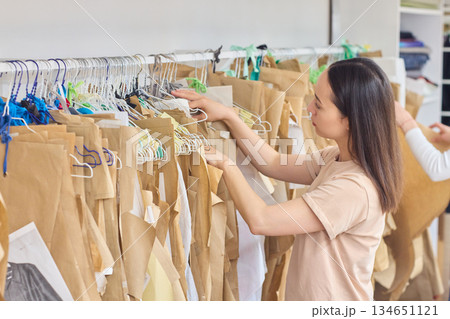 A woman is efficiently organizing the fashion media stock in her creative workspace environment A woman is efficiently organizing the fashion media stock in her creative workspace environment 134651121