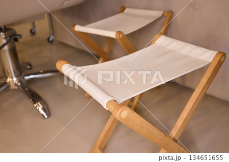 Collapsible wooden bench featuring fabric seat in modern , Versatile foldaway wooden stool with fabric surface situated in bright Scandinavian inspired setting 134651655