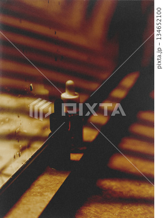 Abstract still life of dropper bottles with shadows and warm tones. The image captures the essence of beauty and skincare with a focus on the shadows. 134652100