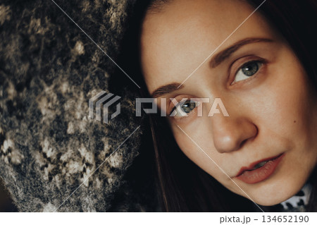 Close-up portrait of a young woman with natural makeup, soft lighting, warm tones. Intimate mood, focus on blue eyes Emotional, artistic female photo 134652190