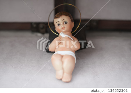 A figurine of a small newborn Jesus Christ. Christmas nativity scene 134652301