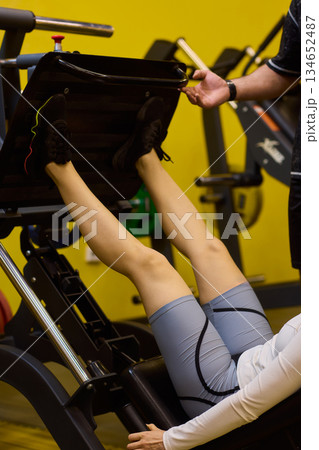 Woman exercises intensely, Intensive workout focusing on proper technique, Dynamic gym environment showing woman engaging muscles during targeted resistance training 134652487
