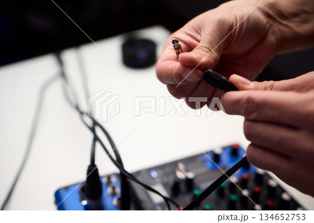 Audio setup preparation, Closeup images of connections during soundcheck setup process, Scene capturing stabilizing cables and adjusting controls before recording begins Audio setup preparation, Closeup images of connections during soundcheck setup process, Scene capturing stabilizing cables and adjusting controls before recording begins 134652753