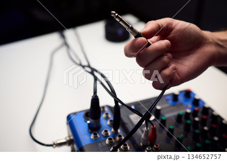 Audio setup preparation, Closeup images of connections during soundcheck setup process, Scene capturing stabilizing cables and adjusting controls before recording begins Audio setup preparation, Closeup images of connections during soundcheck setup process, Scene capturing stabilizing cables and adjusting controls before recording begins 134652757