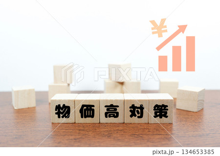 物価高対策を示す木製ブロックと円マークの上昇グラフ。 134653385