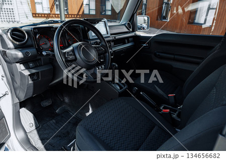 Interior of a modern vehicle showcasing dashboard and seating in bright surroundings 134656682