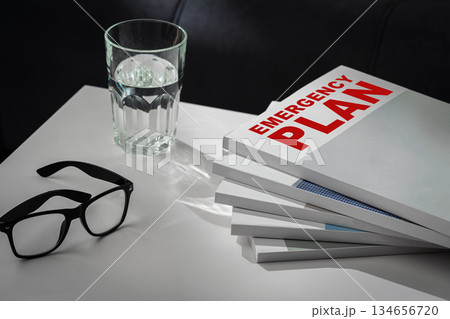Preparing for safety with an emergency plan and glasses beside a glass of water 134656720