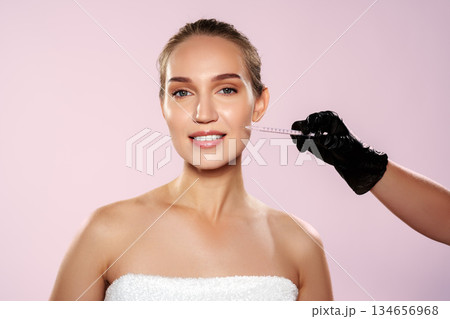 Woman receives treatment with syringe at beauty clinic in bright room 134656968