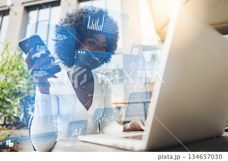 Woman working on laptop with digital data displayed on screen in an outdoor setting 134657030