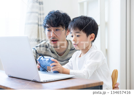 ファミリー　パソコンゲームでゲームを楽しむ男の子とパパ 134657416