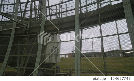maintenance ladder inside weathered radar enclosure. narrow catwalk and grated steps leading through rusted girder framework, safety railings, bolt plates, confined service corridor, atmosphere maintenance ladder inside weathered radar enclosure. narrow catwalk and grated steps leading through rusted girder framework, safety railings, bolt plates, confined service corridor, atmosphere 134657748