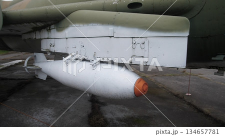 loaders position explosive ordinances, external device equipped beneath aircraft fuselage, ordnance specialists systematically stage explosive devices under aircraft fuselage for deployment 134657781