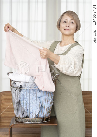 家事の洗濯をするシニア女性 家事の洗濯をするシニア女性 134658431