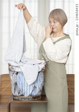 家事の洗濯をするシニア女性 家事の洗濯をするシニア女性 134658433