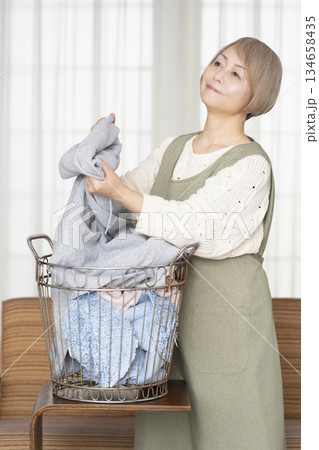 家事の洗濯をするシニア女性 家事の洗濯をするシニア女性 134658435
