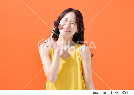 メイクブラシを持った女性 134658583
