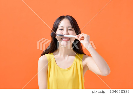 メイクブラシを持った女性 134658585