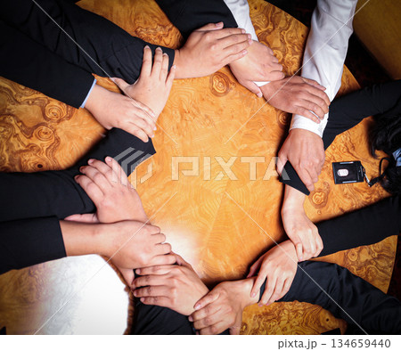 Team Unity, Diverse Hands Joined Together Around Wooden Table in Collaborative Meeting showcasing good teamwork, support and collaboration 134659440