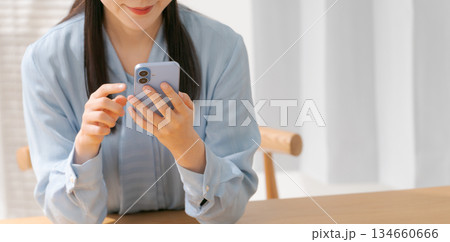スマホを操作する若い女性（バナー） 134660666