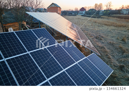 Solar photovoltaic panels for producing of clean ecological electrical energy mounted on backyard ground in suburban rural area. Concept of autonomous home Solar photovoltaic panels for producing of clean ecological electrical energy mounted on backyard ground in suburban rural area. Concept of autonomous home 134661324