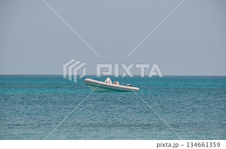 Seascape with ripple surface of blue sea water with white speedboat on anchor floating on calm waves 134661359