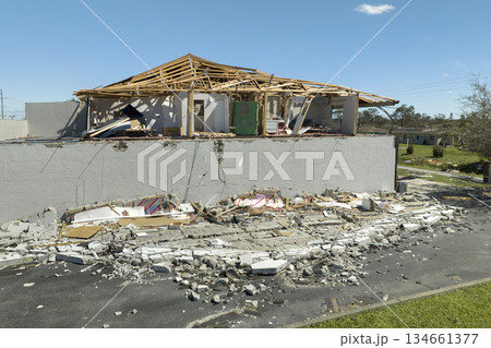 Ruined building in need of repair. Wind damaged house roof with missing asphalt shingles and collapsed wall after hurricane Ian in Florida Ruined building in need of repair. Wind damaged house roof with missing asphalt shingles and collapsed wall after hurricane Ian in Florida 134661377