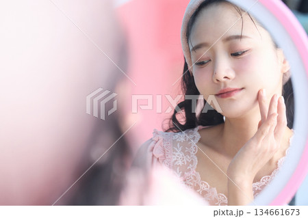 鏡の前でポーズをする若くてかわいいアジアの女性の美容ポートレート 鏡の前でポーズをする若くてかわいいアジアの女性の美容ポートレート 134661673