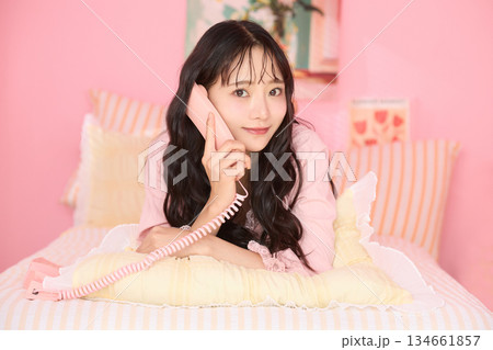 カラフルなベッドルームでリラックスする若い女性のかわいいポートレート カラフルなベッドルームでリラックスする若い女性のかわいいポートレート 134661857