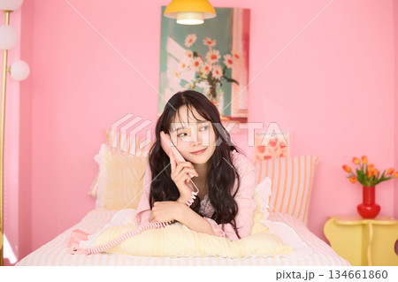 カラフルなベッドルームでリラックスする若い女性のかわいいポートレート	 134661860