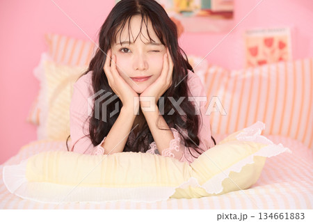 カラフルなベッドルームでリラックスする若い女性のかわいいポートレート	 134661883