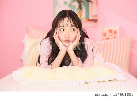 カラフルなベッドルームでリラックスする若い女性のかわいいポートレート	 134661885