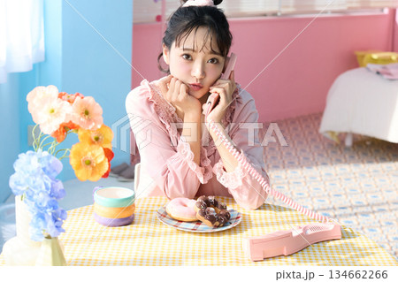 カラフルな部屋でドーナツを食べるかわいい女性のポートレート 134662266