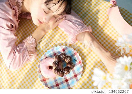 カラフルな部屋でドーナツを食べるかわいい女性のポートレート 134662267