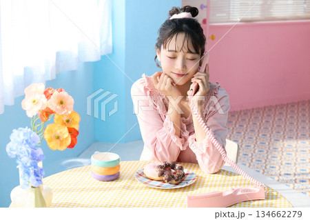 カラフルな部屋でドーナツを食べるかわいい女性のポートレート 134662279