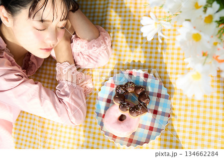 カラフルな部屋でドーナツを食べるかわいい女性のポートレート 134662284