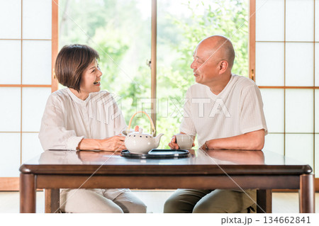 新緑の見える和室でお茶を飲むシニア夫婦 134662841