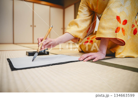 着物で習字をしている手元 134663599