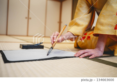 着物で習字をしている手元 134663600